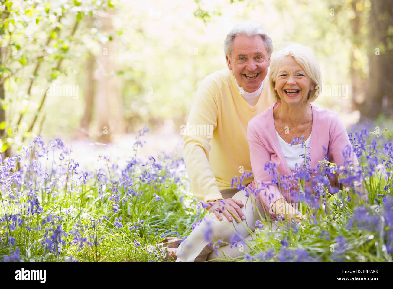 Couple sitting outdoors with flowers smiling Stock Photo