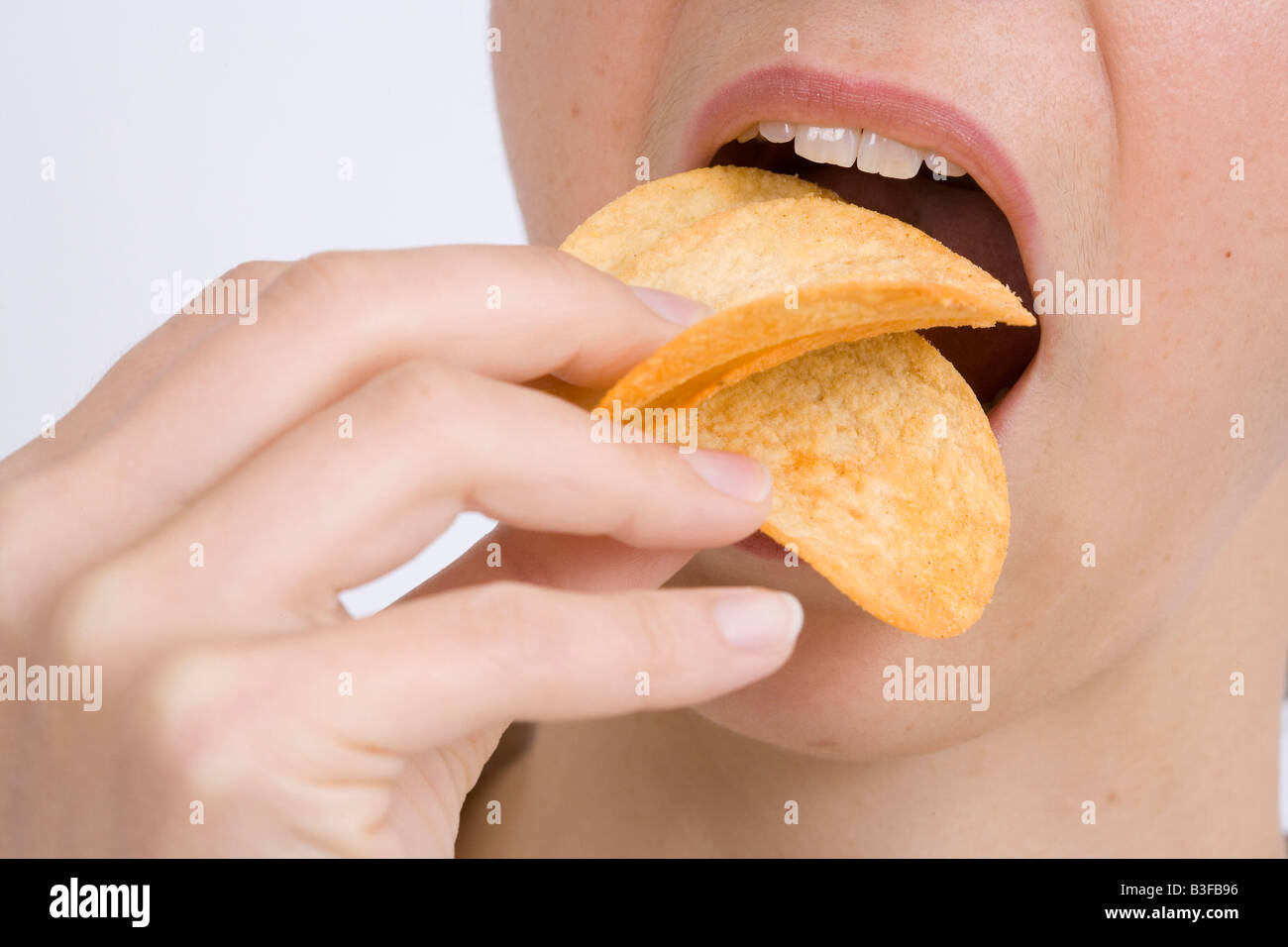 Woman eating crisps Stock Photo