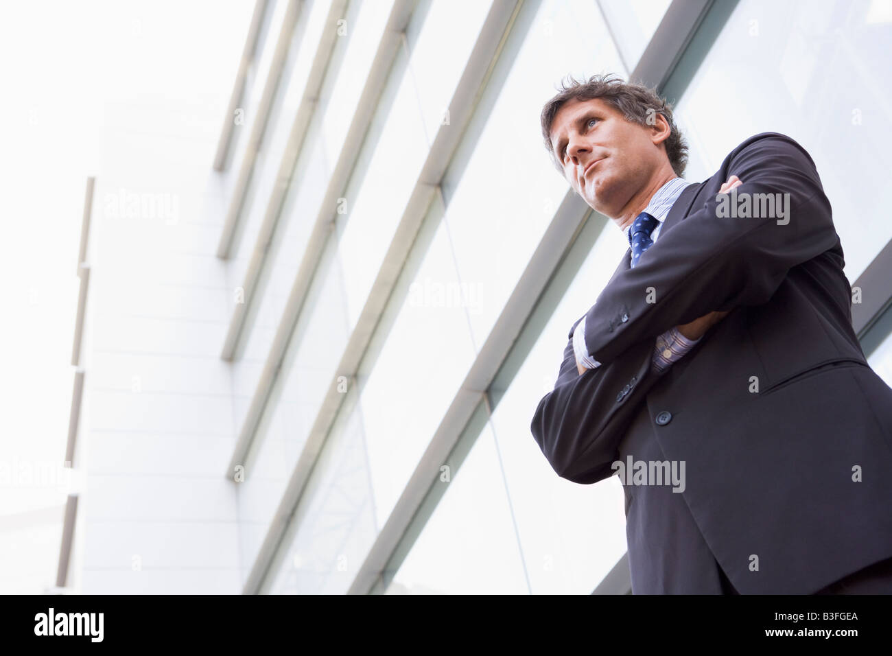 Businessman standing outdoors by building Stock Photo - Alamy
