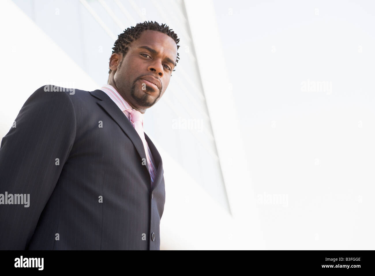 Businessman standing outdoors by building Stock Photo - Alamy