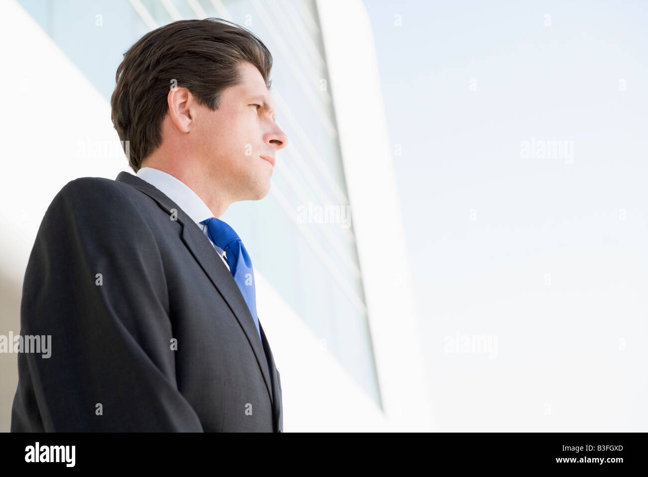 Businessman standing outdoors by building Stock Photo - Alamy