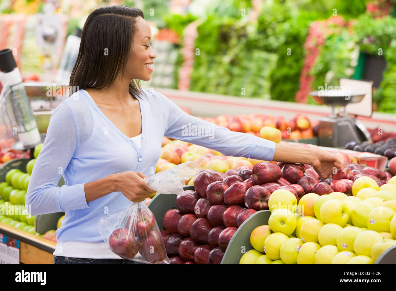Woman shopping for apples at a grocery store Stock Photo Alamy