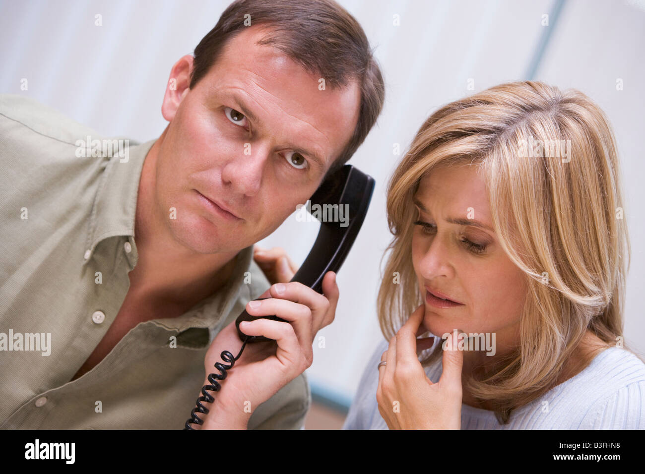 Couple receiving a bad news phone call from clinic Stock Photo