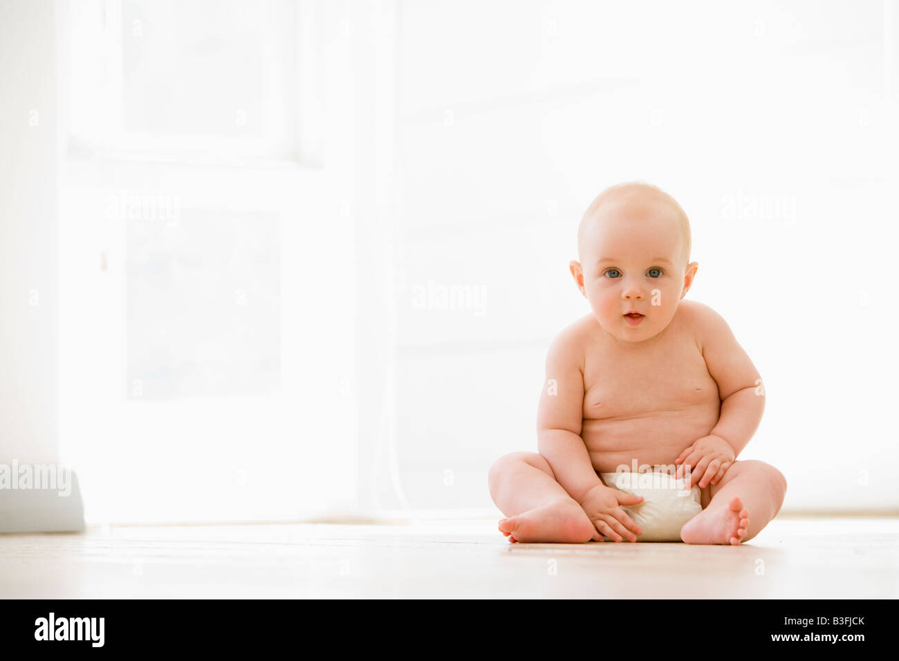 Baby sitting indoors Stock Photo Alamy