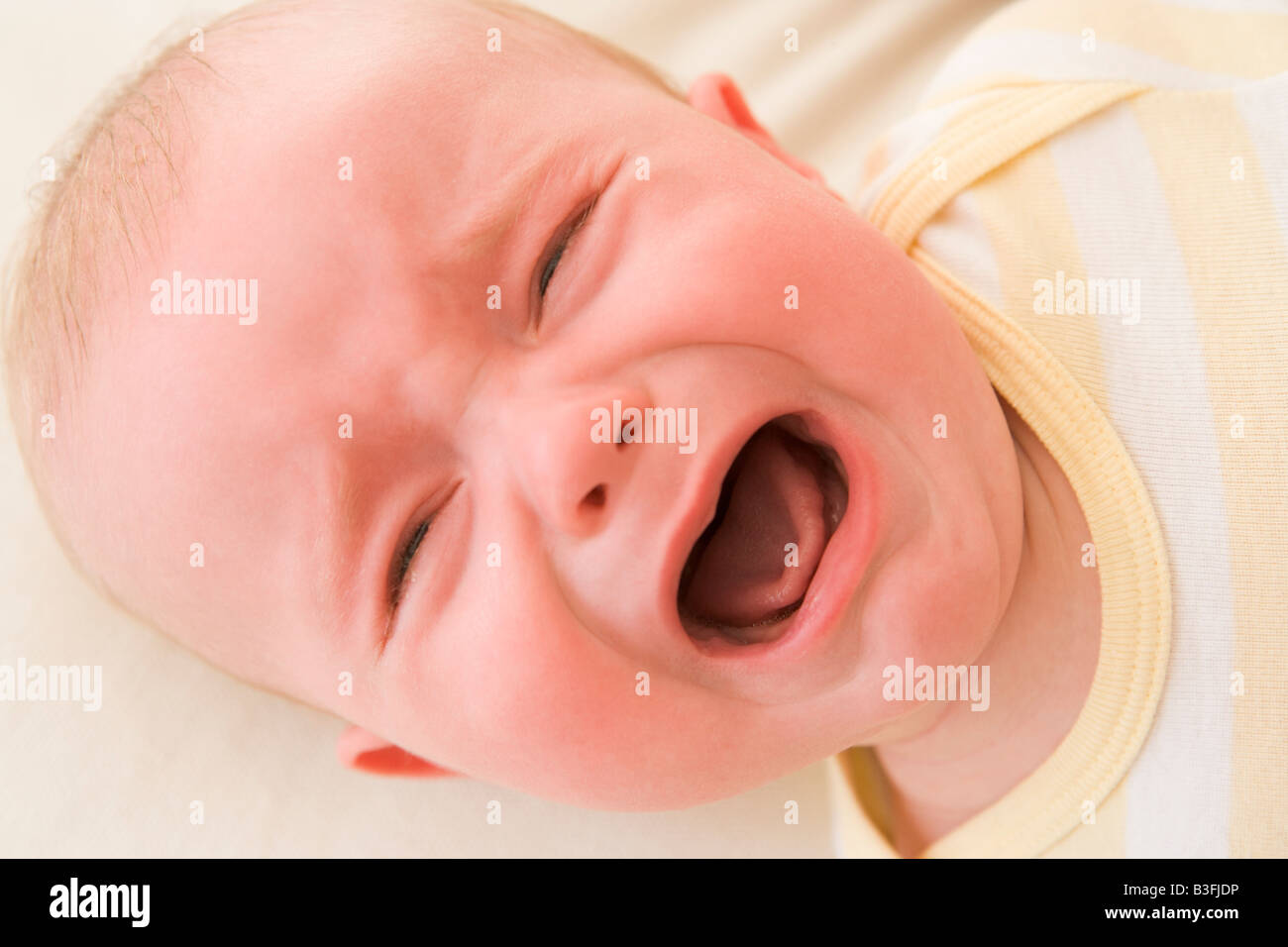 Baby lying indoors crying Stock Photo