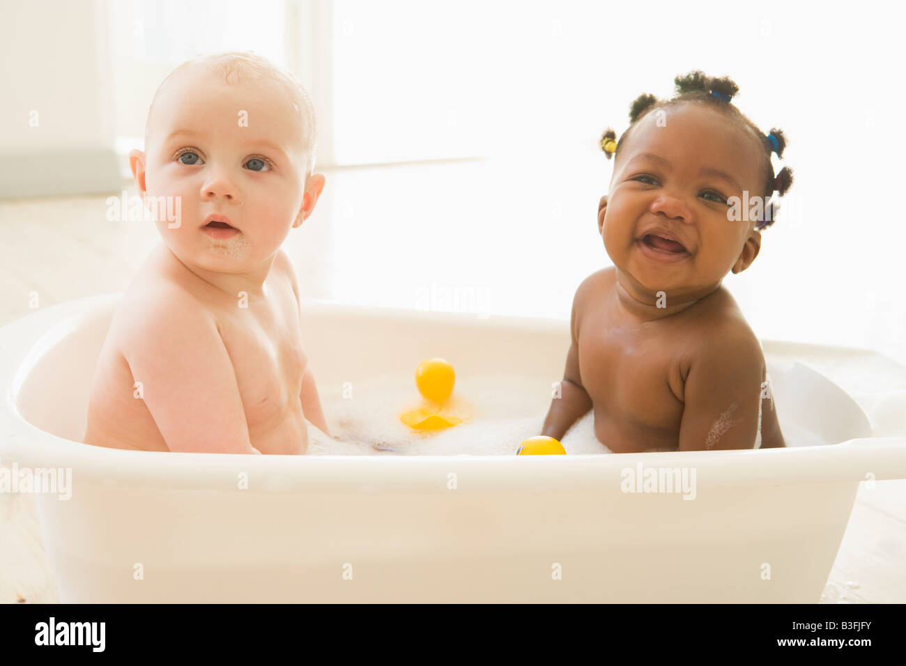 Two babies in bubble bath Stock Photo