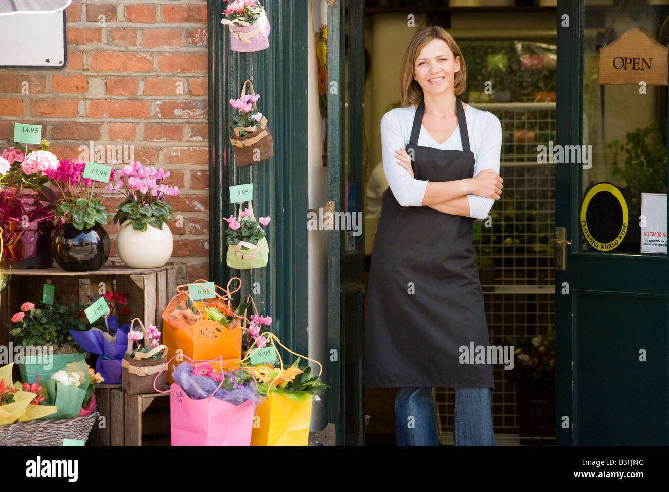 Woman working at flower shop smiling Stock Photo