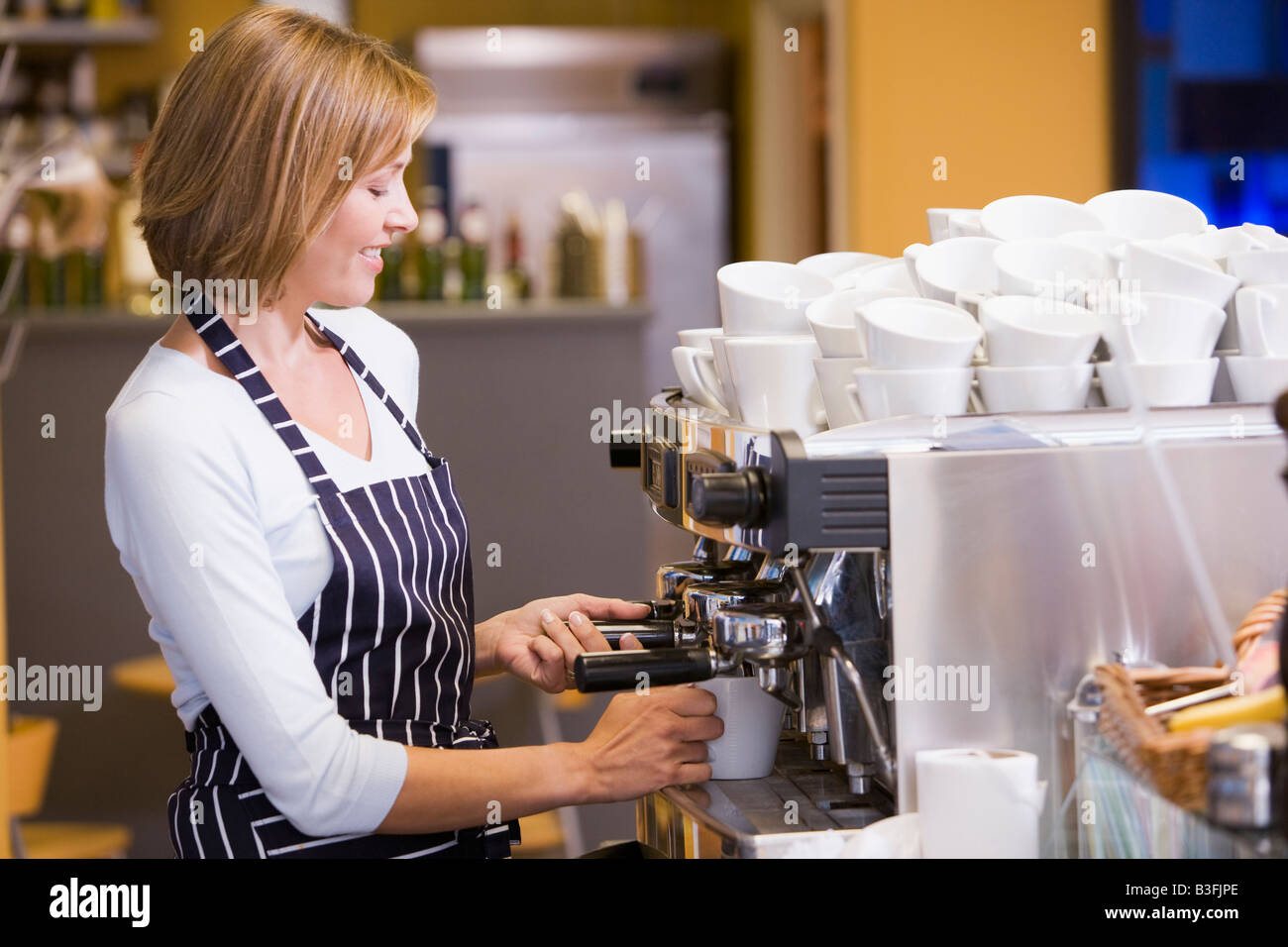 Woman making coffee in restaurant smiling Stock Photo Alamy
