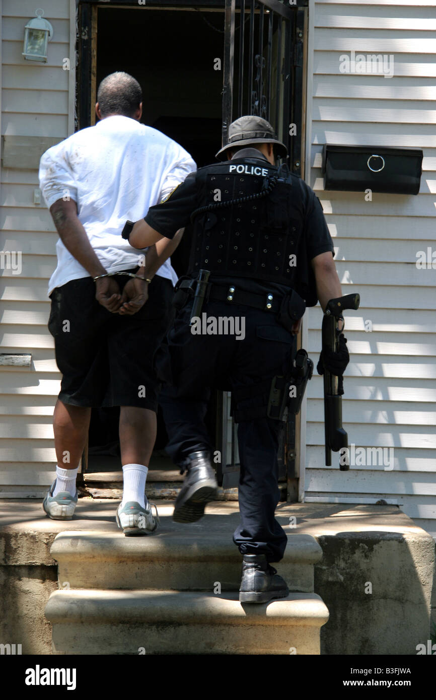 Detroit Narc cop with arrested suspect after a drugs raid on a suspected crack house Stock Photo