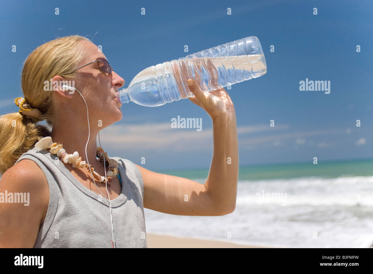 young woman having a drink of water at the beach Stock Photo - Alamy