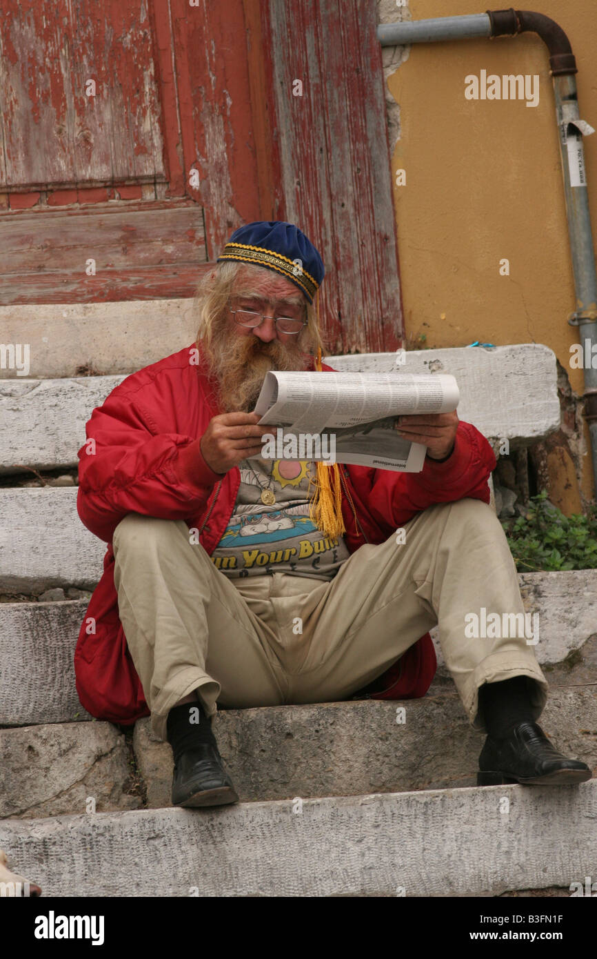 Israel Jerusalem a mature man sitting on the steps reading an English newspaper Stock Photo