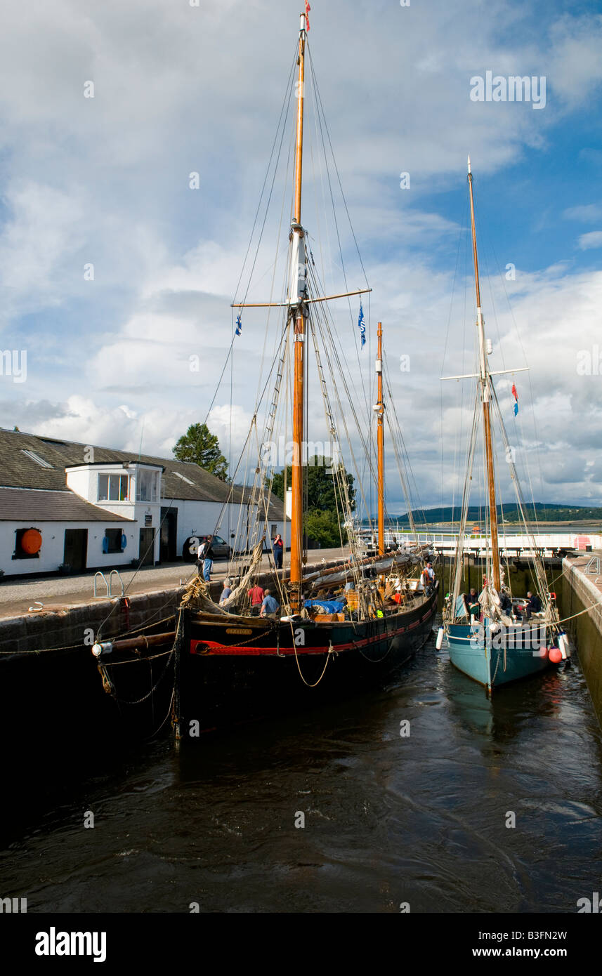 'Leader' on her way home through the Caledonian Canal in Scotland from the 2008 Tall Ships Race alongside a smaller Gaff Cutter Stock Photo