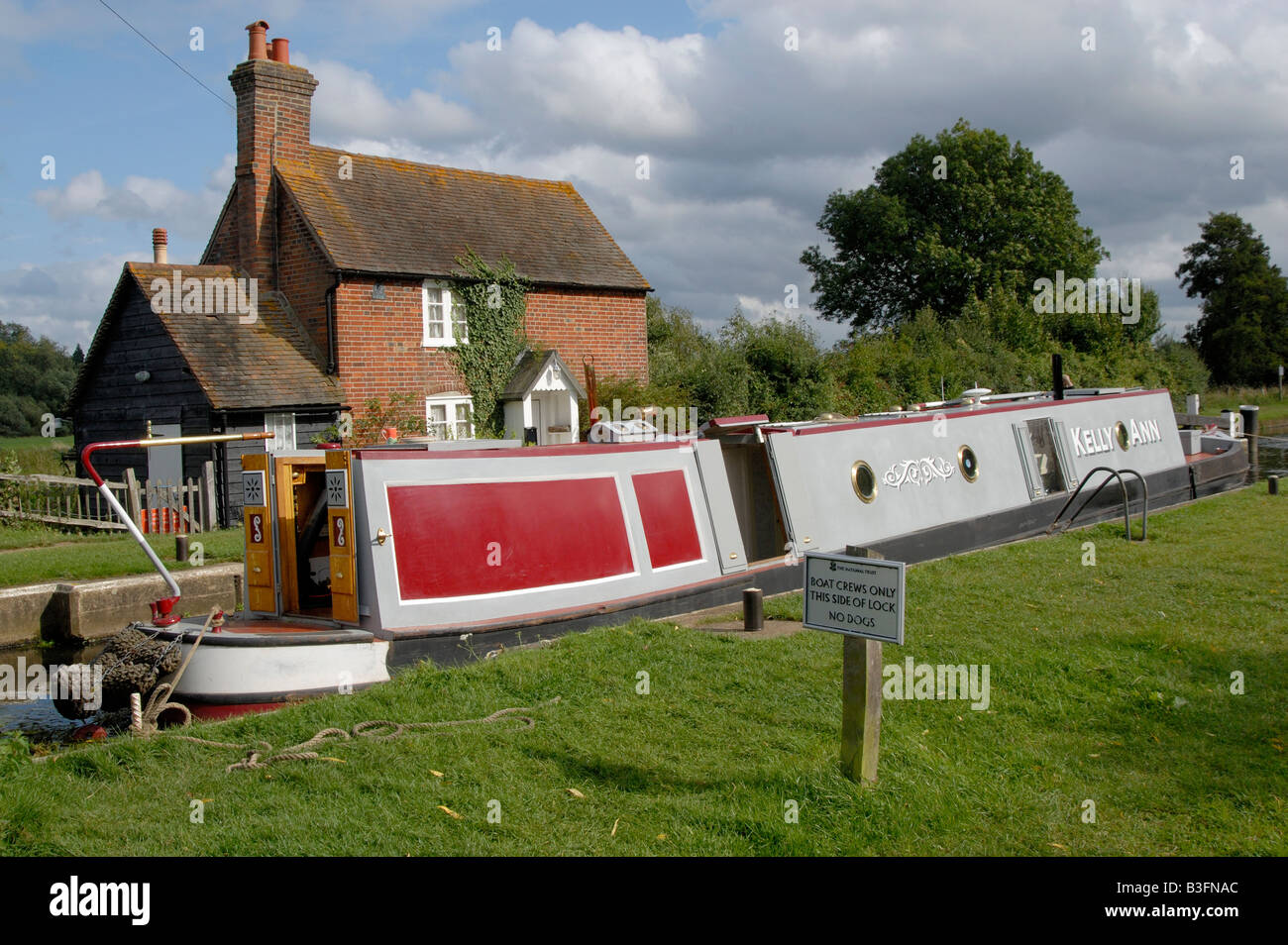 Traditional narrowboat passing through Triggs Lock on the River Wey Navigation near Woking, Surrey, England Stock Photo