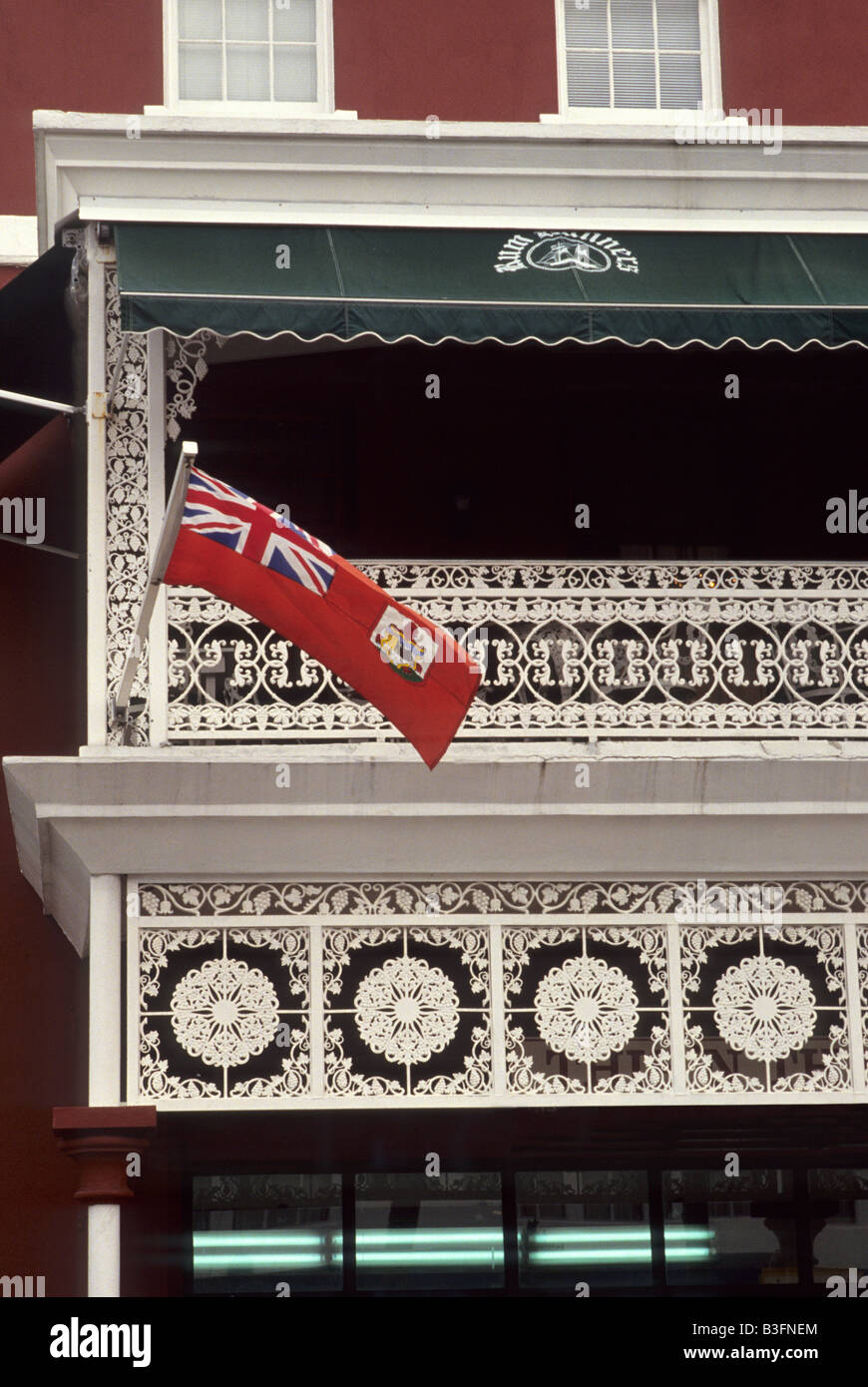 Bermudan flag, flying from intricate white wrought iron balcony on Front Street, Hamilton, Bermuda Stock Photo