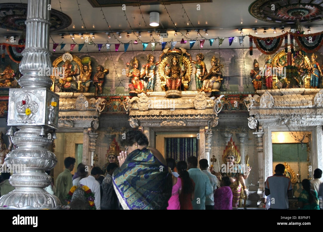Worshippers inside Sri Veeramakaliamman Temple , Singapore , South East Asia Stock Photo