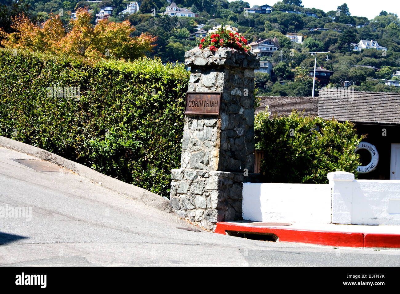 Stone pillar with flowers on top with the word 'Corinthian' on a metal plaque in Tiburon, California Stock Photo