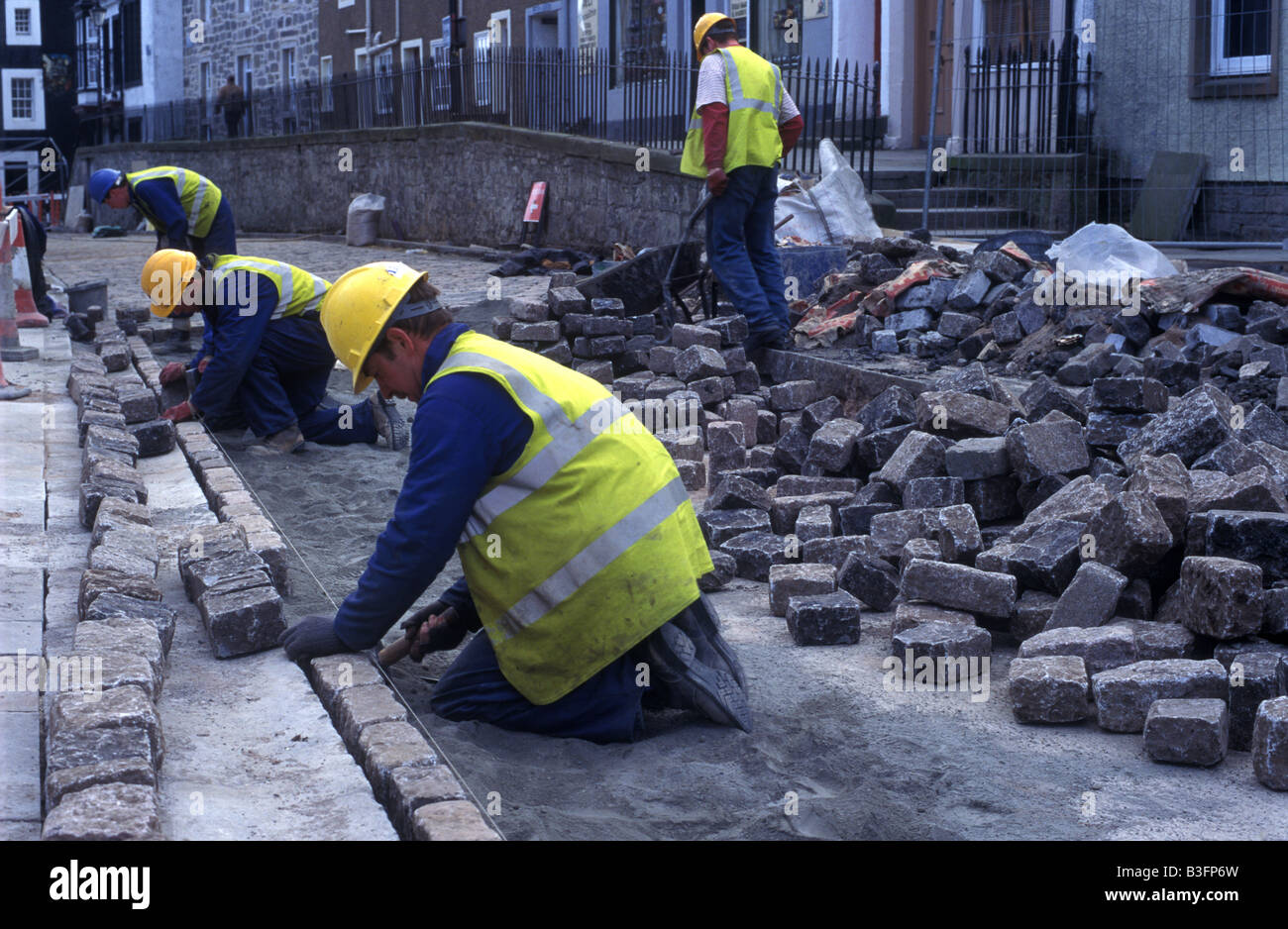 Workmen laying cobblestones Stock Photo