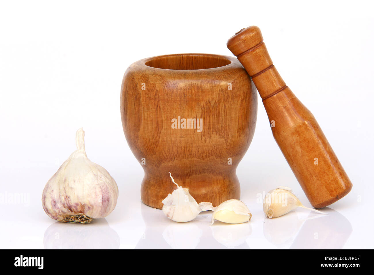 wooden mortar and pestle with garlic isolated with reflection Stock