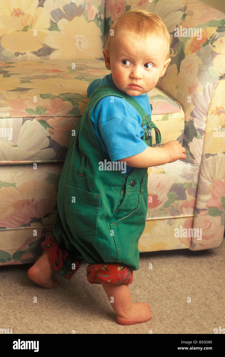 baby learning to pull himself up with help of a chair Stock Photo Alamy