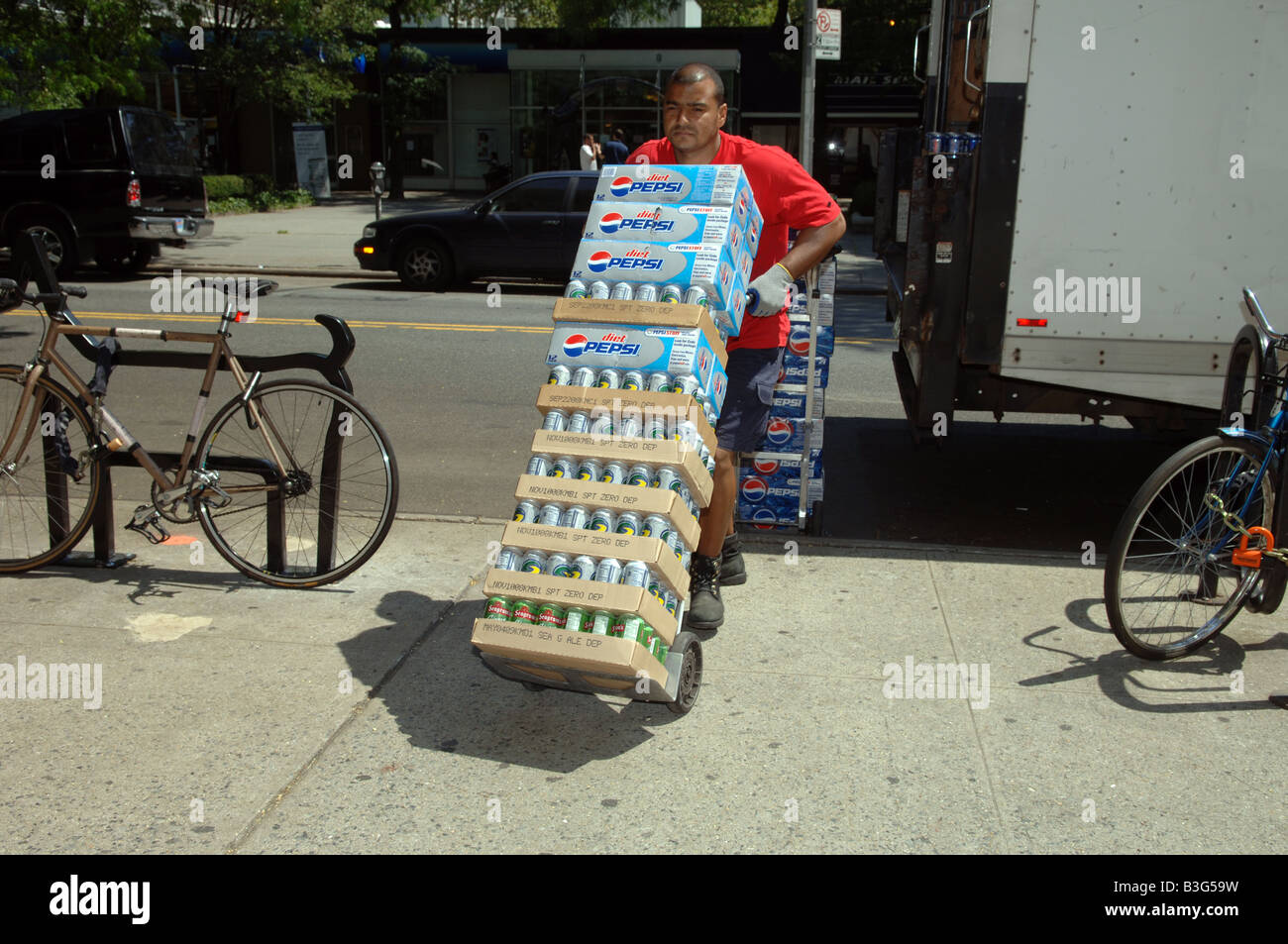Delivery man brings a supply of soda including Diet Pepsi Cola to a grocery in New York Stock Photo