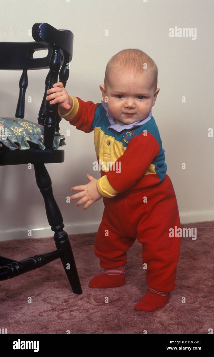 baby pulling himself up with help of a chair Stock Photo Alamy