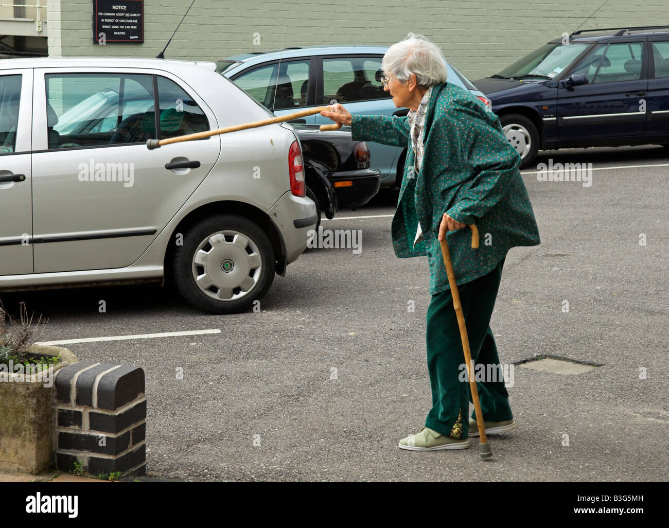 Active elderly English 92 year old woman walking in car park with canes Stock Photo
