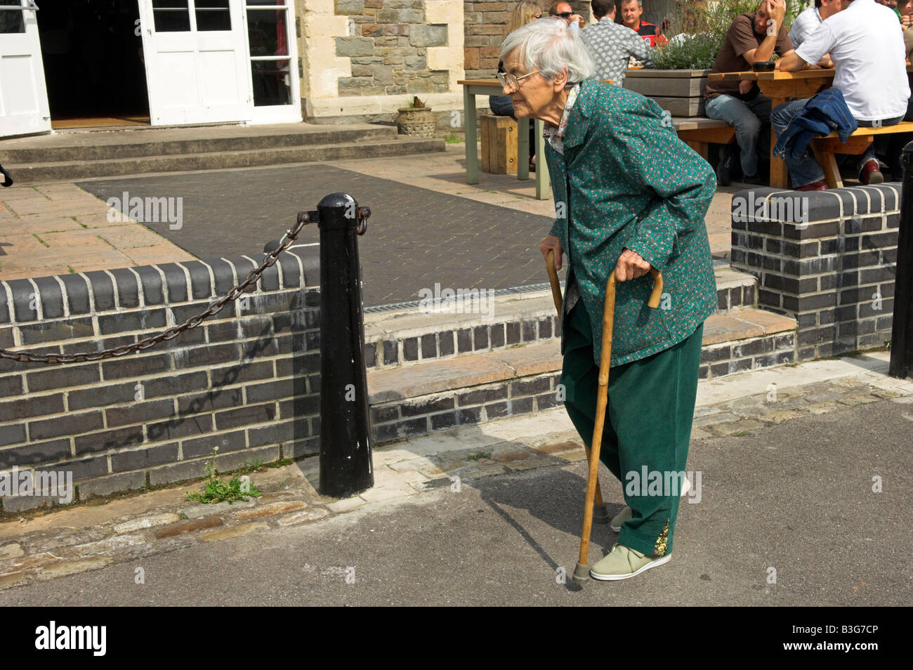 Active elderly English 92 year old woman walking with two canes Stock Photo