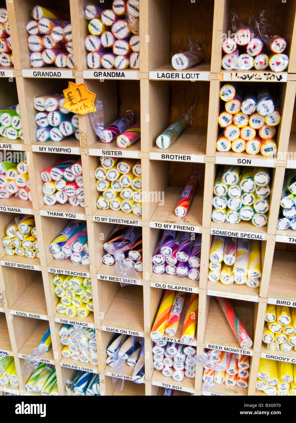 Sticks of rock with saucy messages at a seaside stall England UK Stock Photo