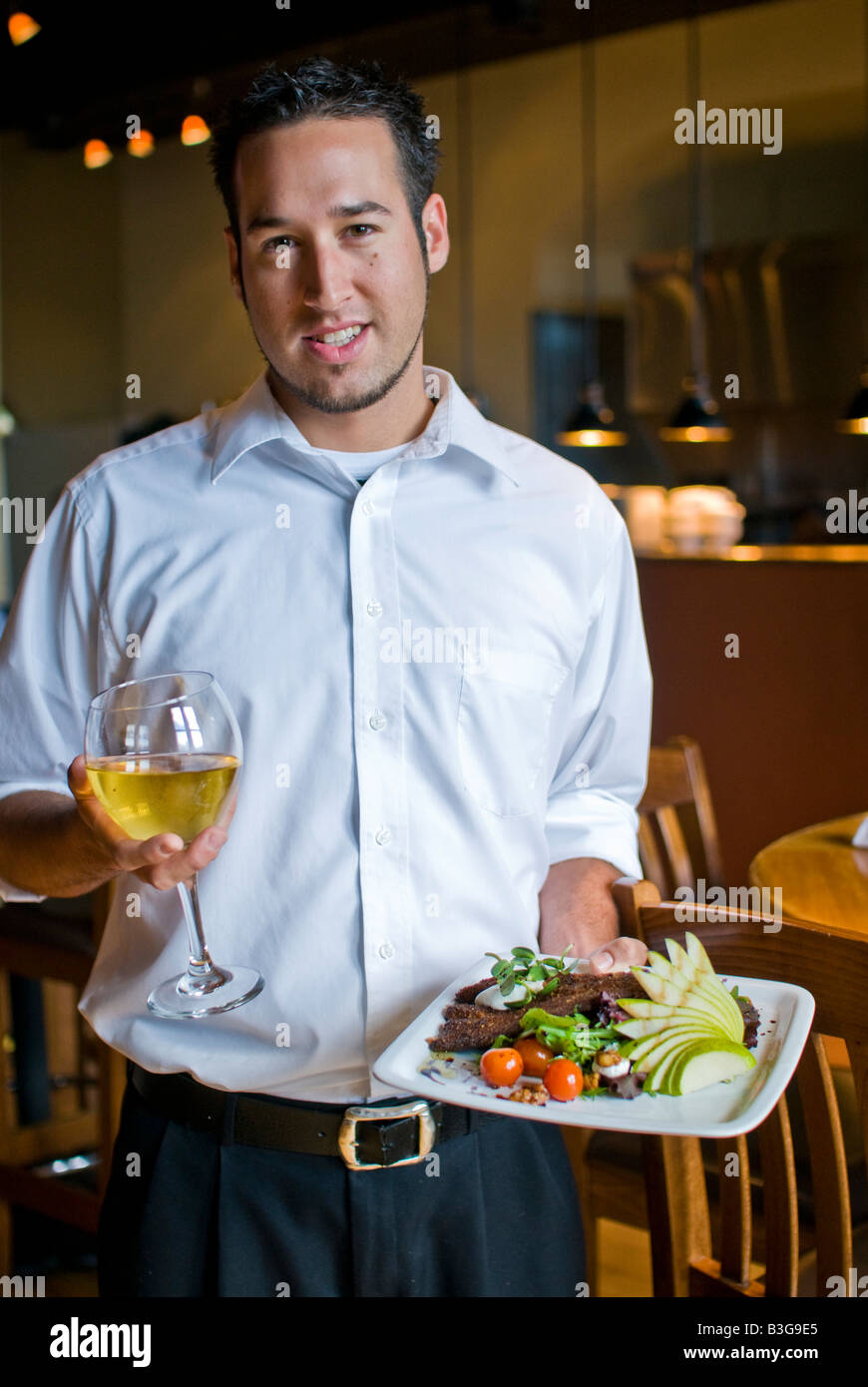 A waiter brings food and wine to people at a nice restaurant Stock ...