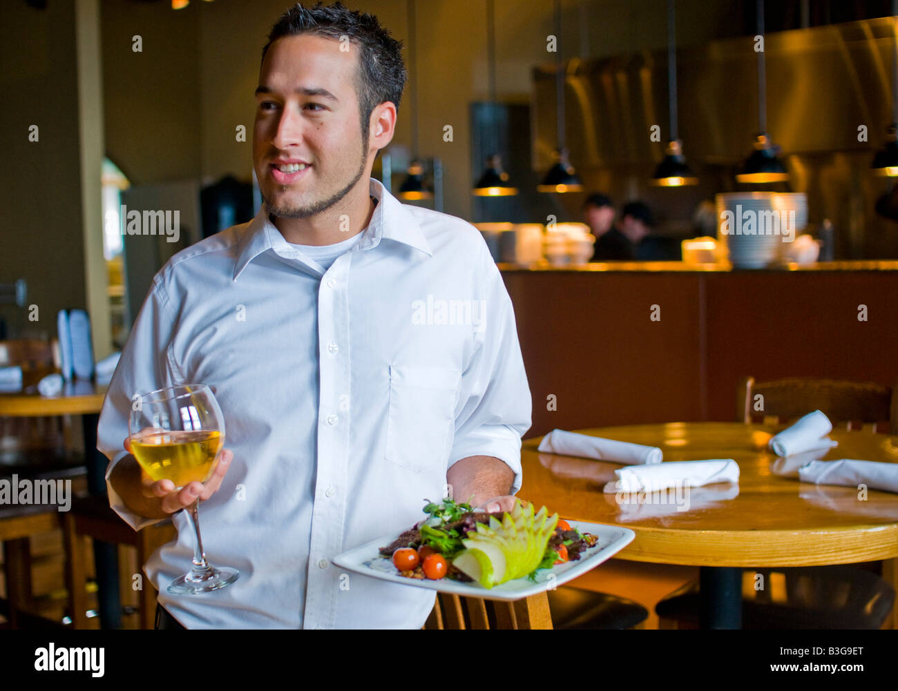 A waiter brings food and wine to people at a nice restaurant Stock ...