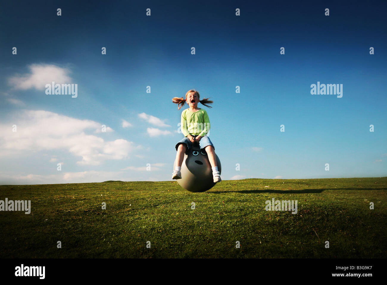 girl bouncing on a space hopper Stock Photo