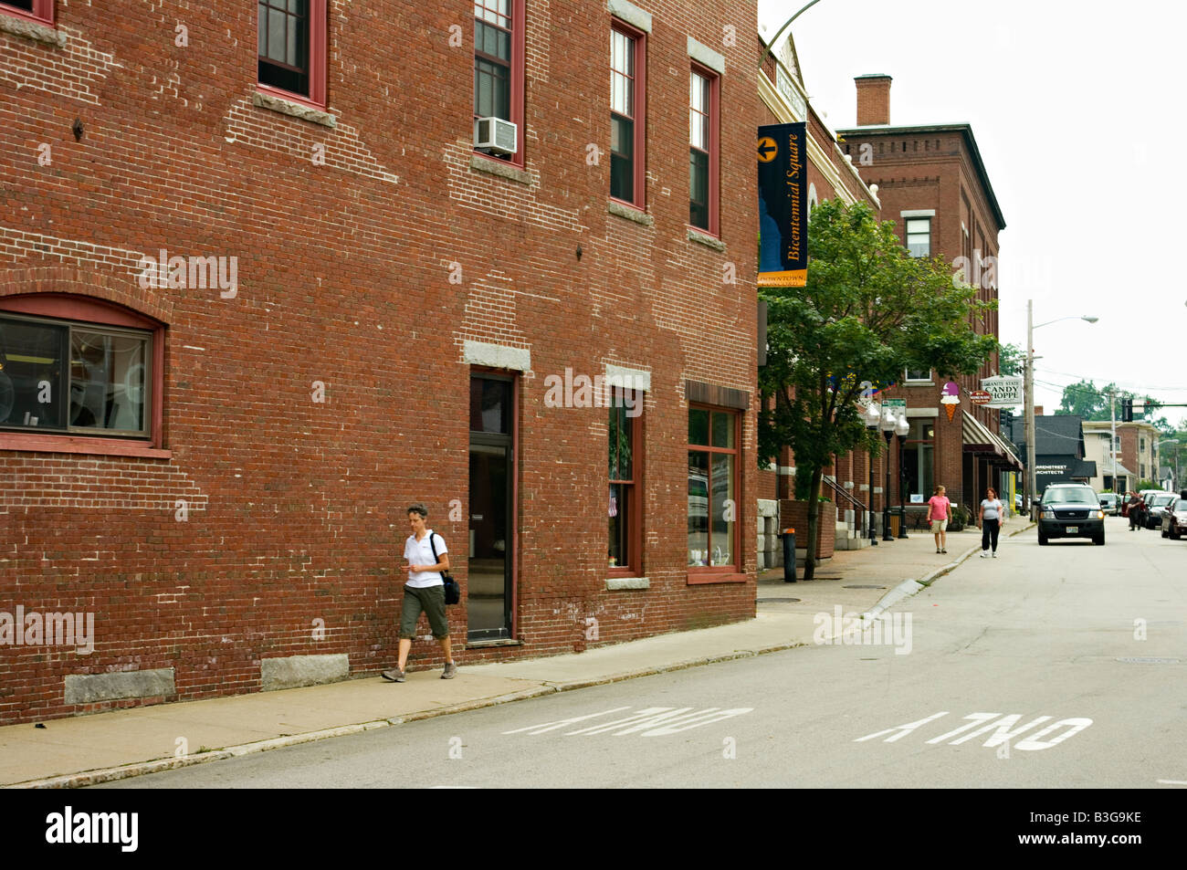 View down a side street in Concord NH US showing old original brick buildings pedestrians cars and commercial signs Editorial. Stock Photo