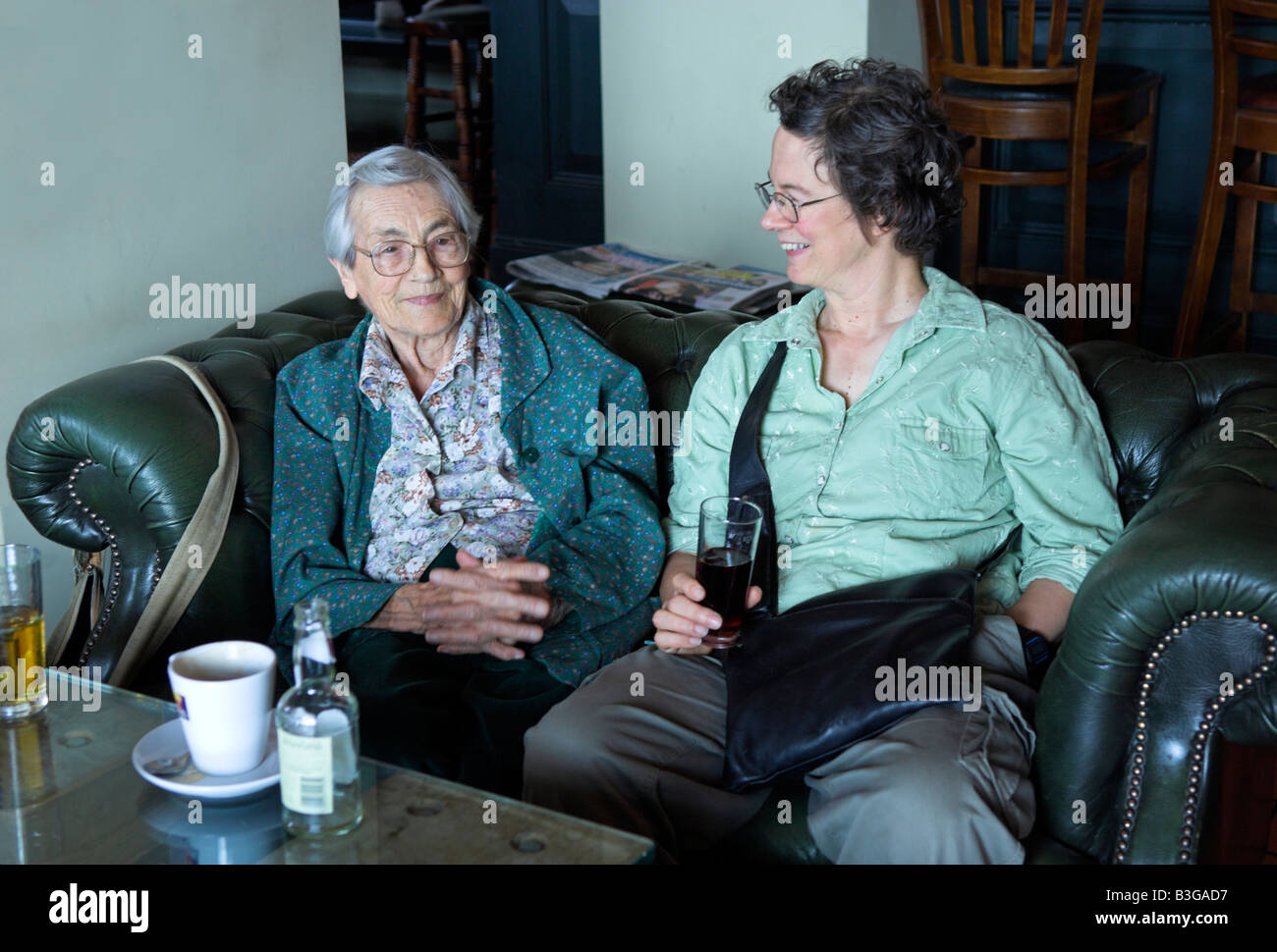 Elderly 92 year old mother and middle aged daughter sitting talking in pub Stock Photo