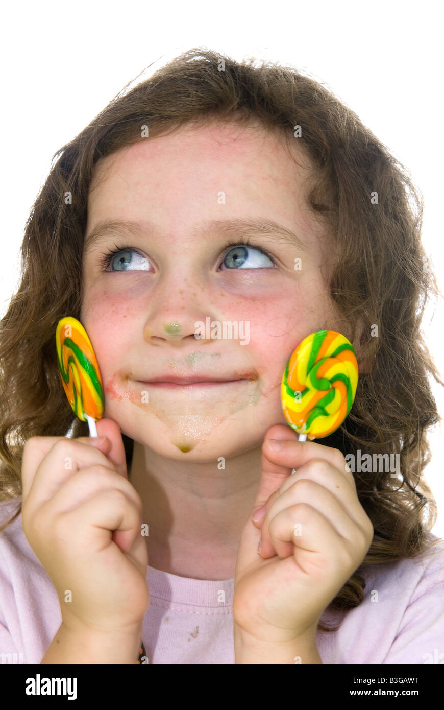 A little girl is guilty of eating two lollipops and looks towards mom for forgiveness Stock Photo