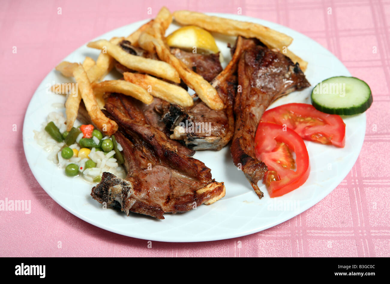 Grilled lamb chops at a greek taverna served with tomato potato chips