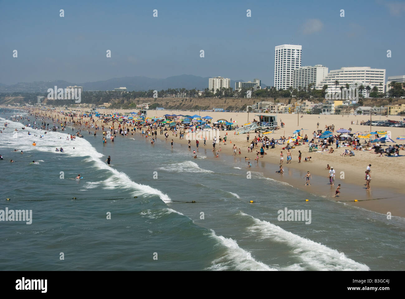 Santa Monica Beach CA  People relaxing, swimming, sunning and having fun playing games, making sandcastles, walking, waves Stock Photo