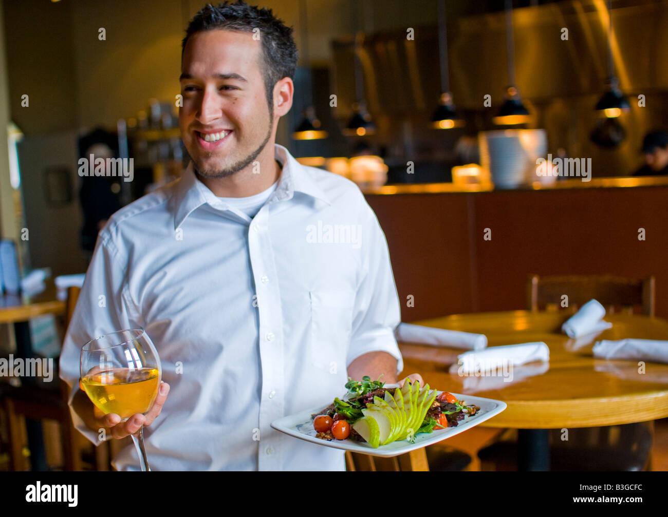 A waiter brings food and wine to people at a nice restaurant Stock ...
