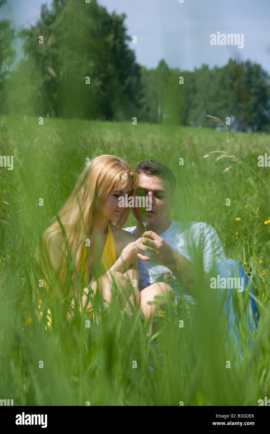 Attractive couple together on meadow in summer day Stock Photo