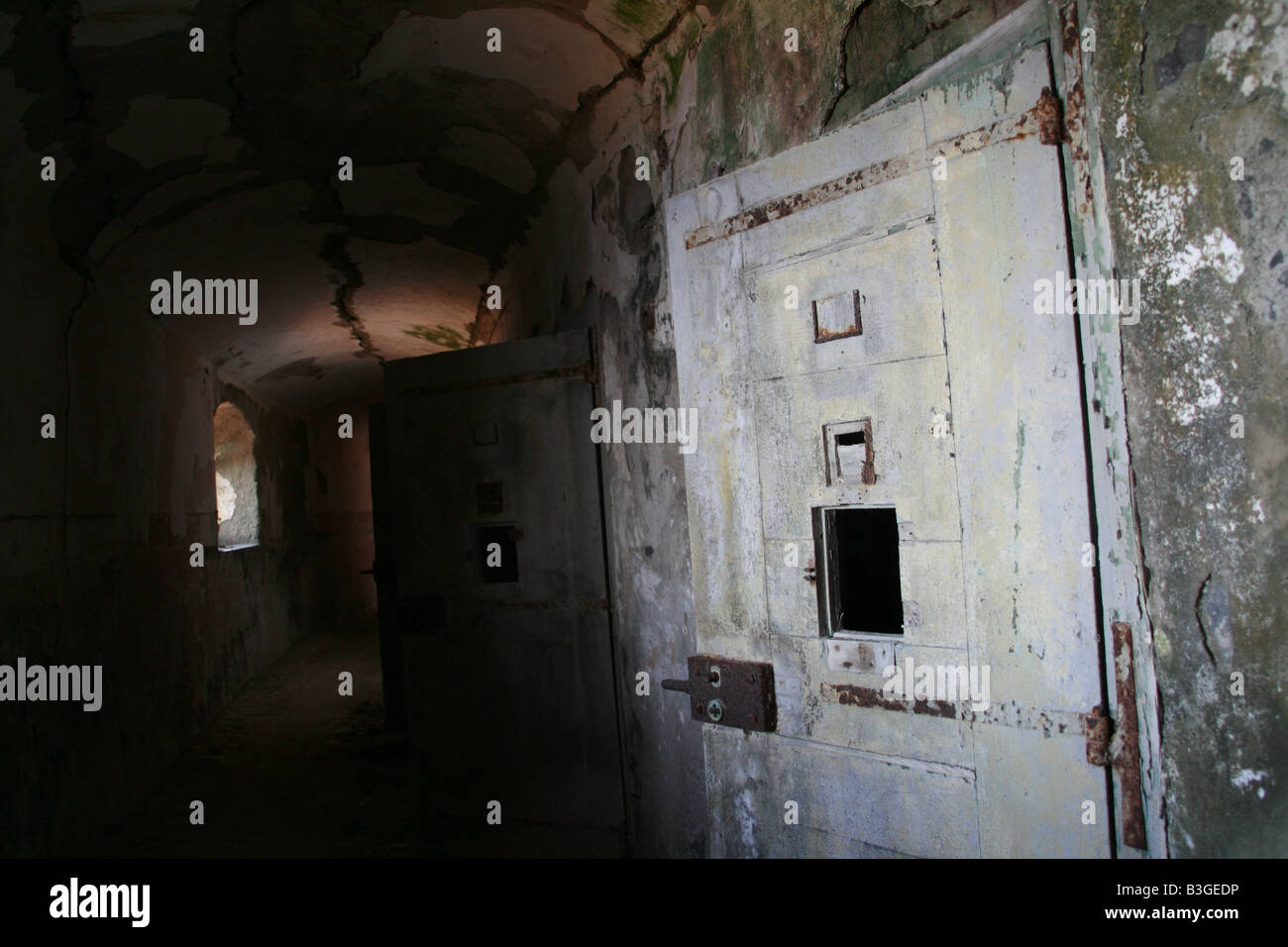 secluded prison cell doors in dark black corridor Stock Photo