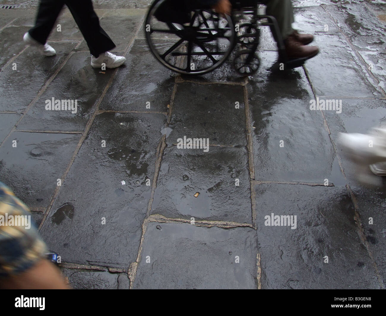 person in wheelchair in heavy rain in city town Stock Photo Alamy