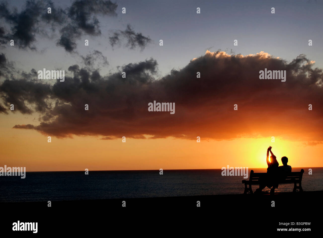 Romantic couple contemplating the sunset- Solstice rite Stock Photo