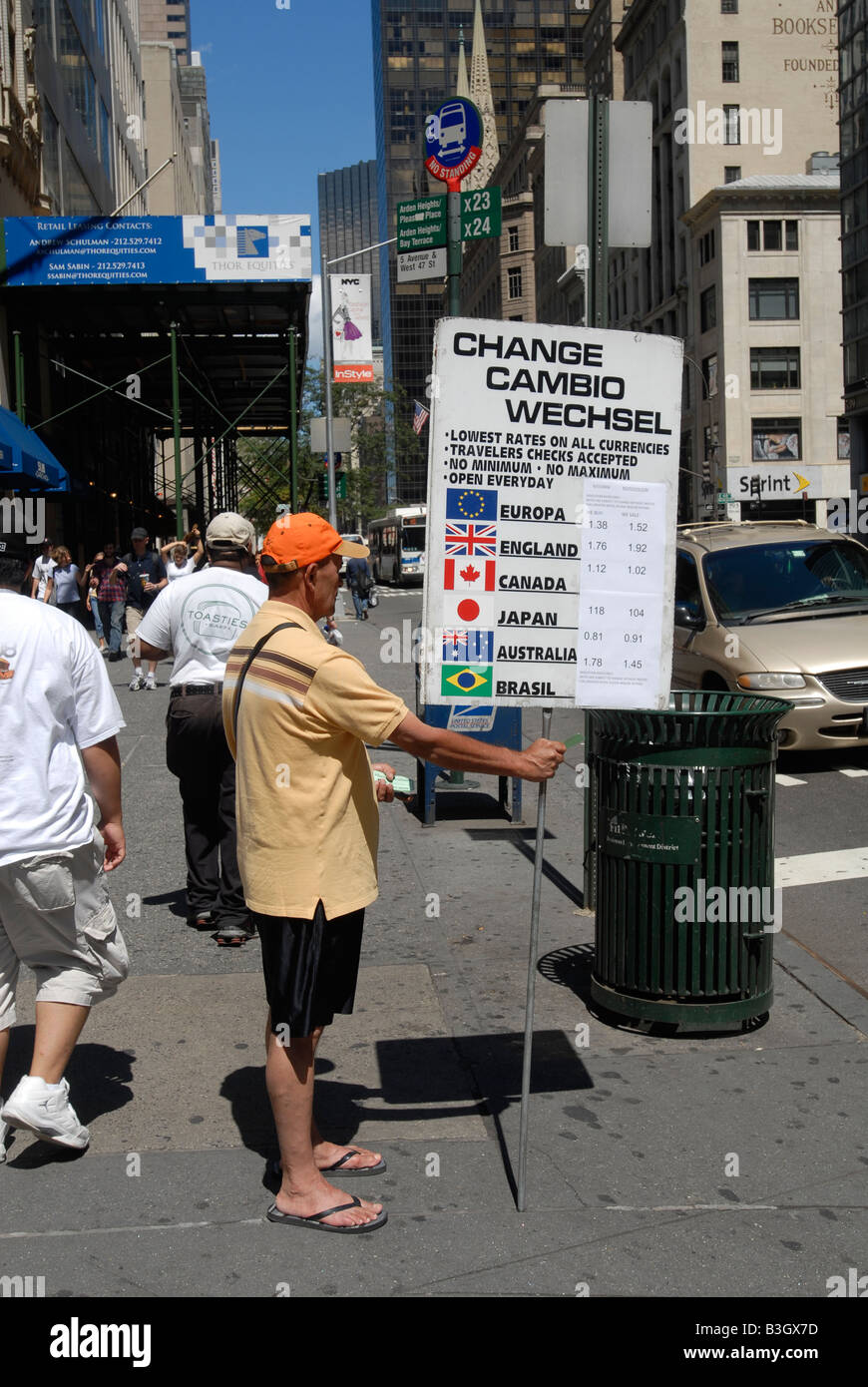 Employee advertises currency exchange on Fifth Avenue in New York on Saturday August 16 2008 Richard B Levine Stock Photo
