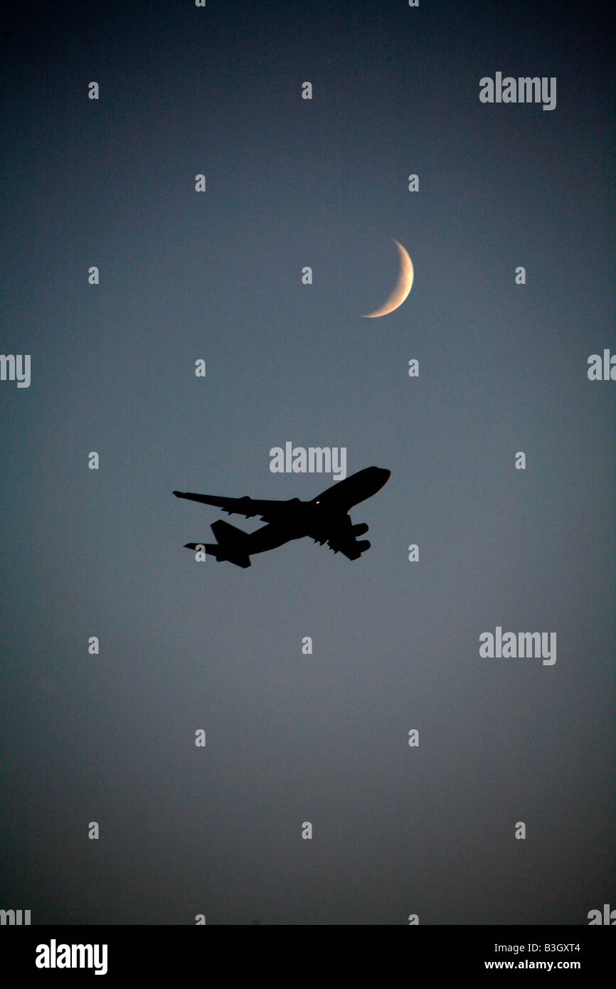 A Boeing 747 wide body Cargo jet approaches landing with new moon Stock Photo