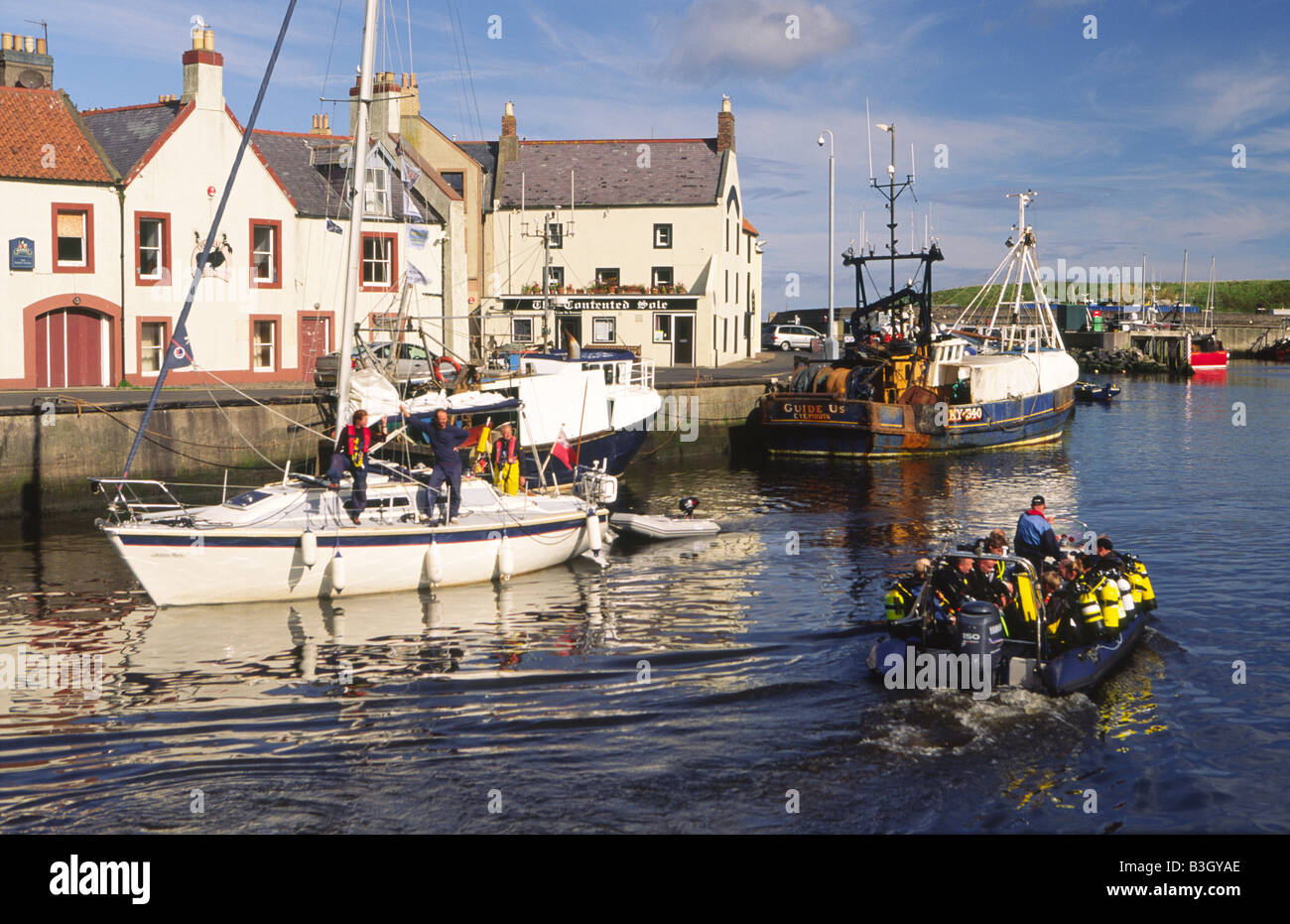 A yacht entering the scenic picuresque fishing town of Eyemouth Harbour ...