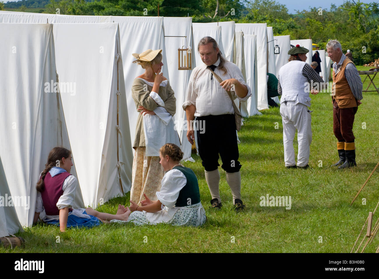 Reenactors relax by encampment tents at Revolutionary War reenactment Mohawk Valley New York State Stock Photo