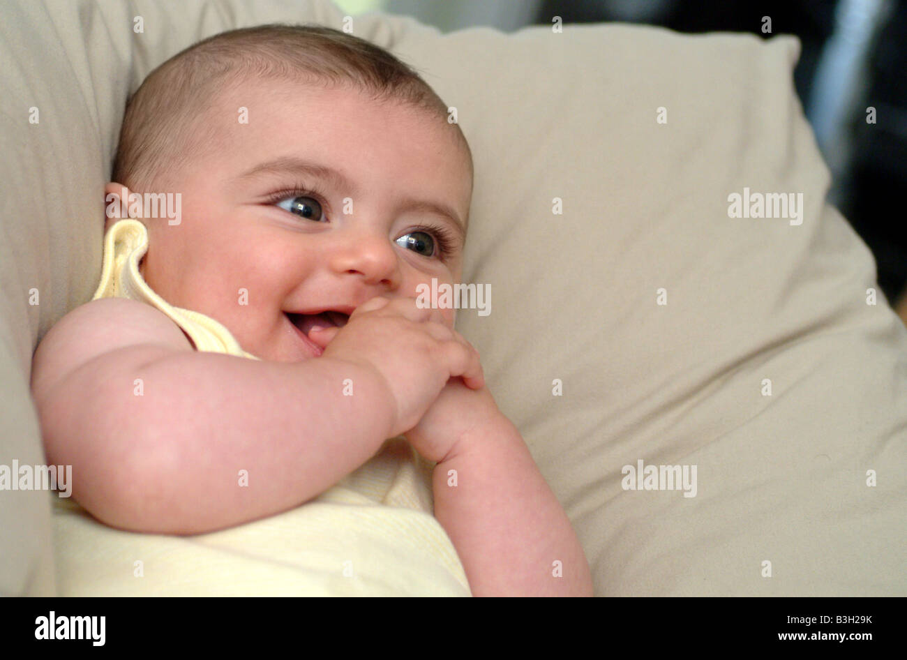 a baby leans on some pillows while watching TV Stock Photo Alamy