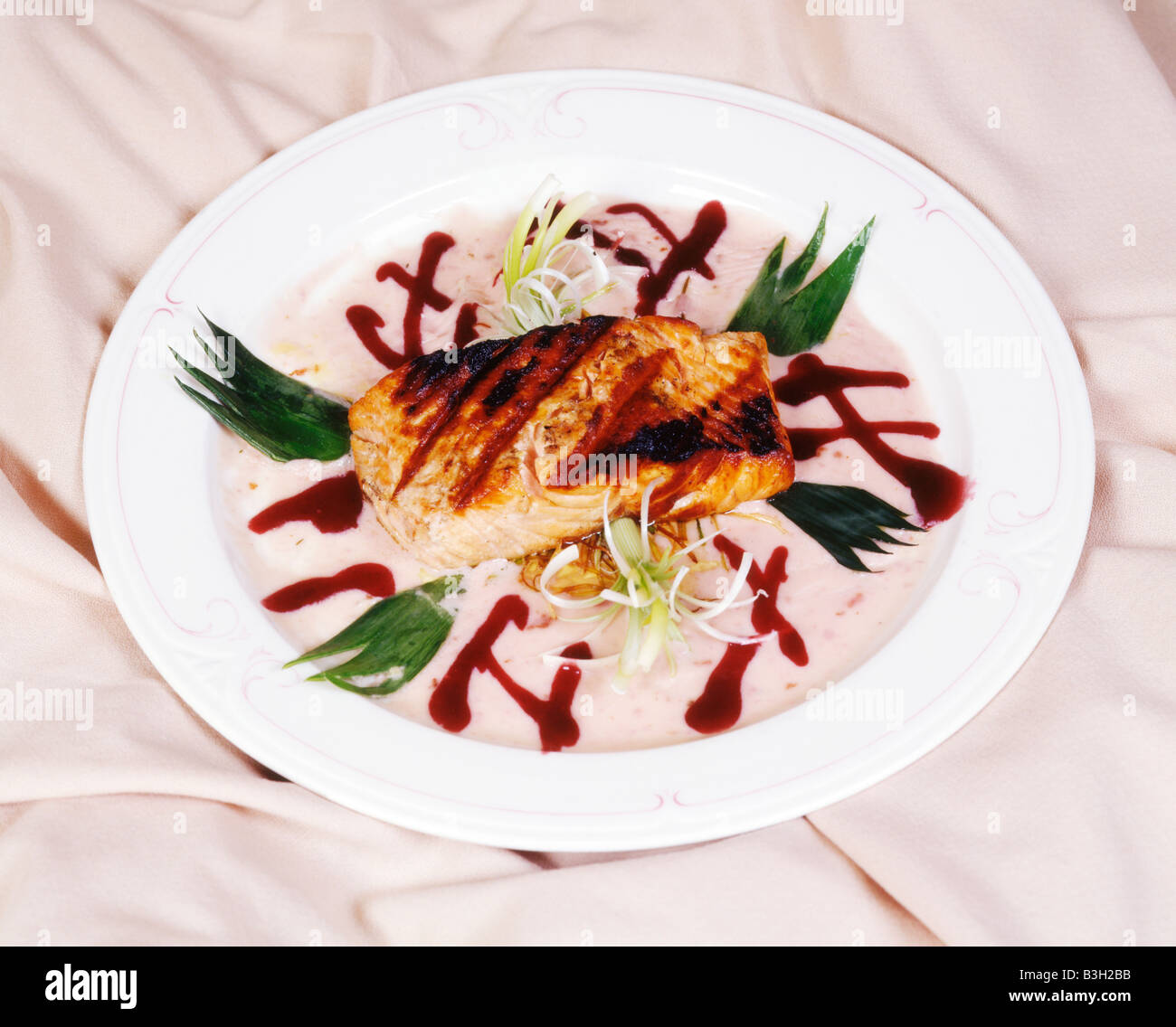 Grilled salmon filet restaurant dinner entree on white plate with garnish Stock Photo