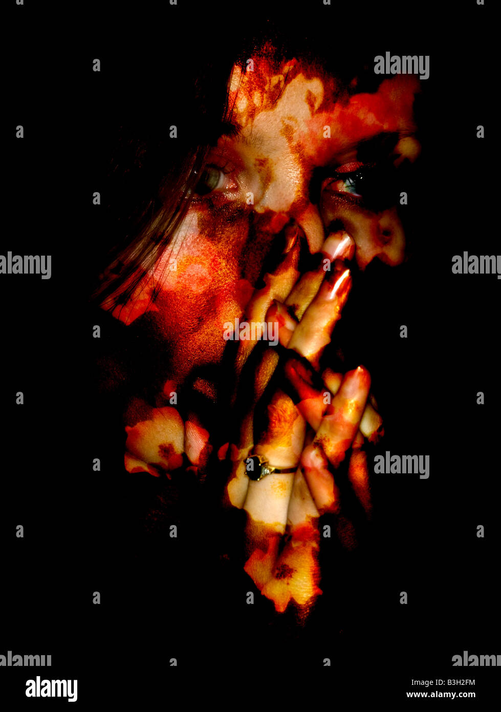 Young woman with hands and face covered in blood Stock Photo