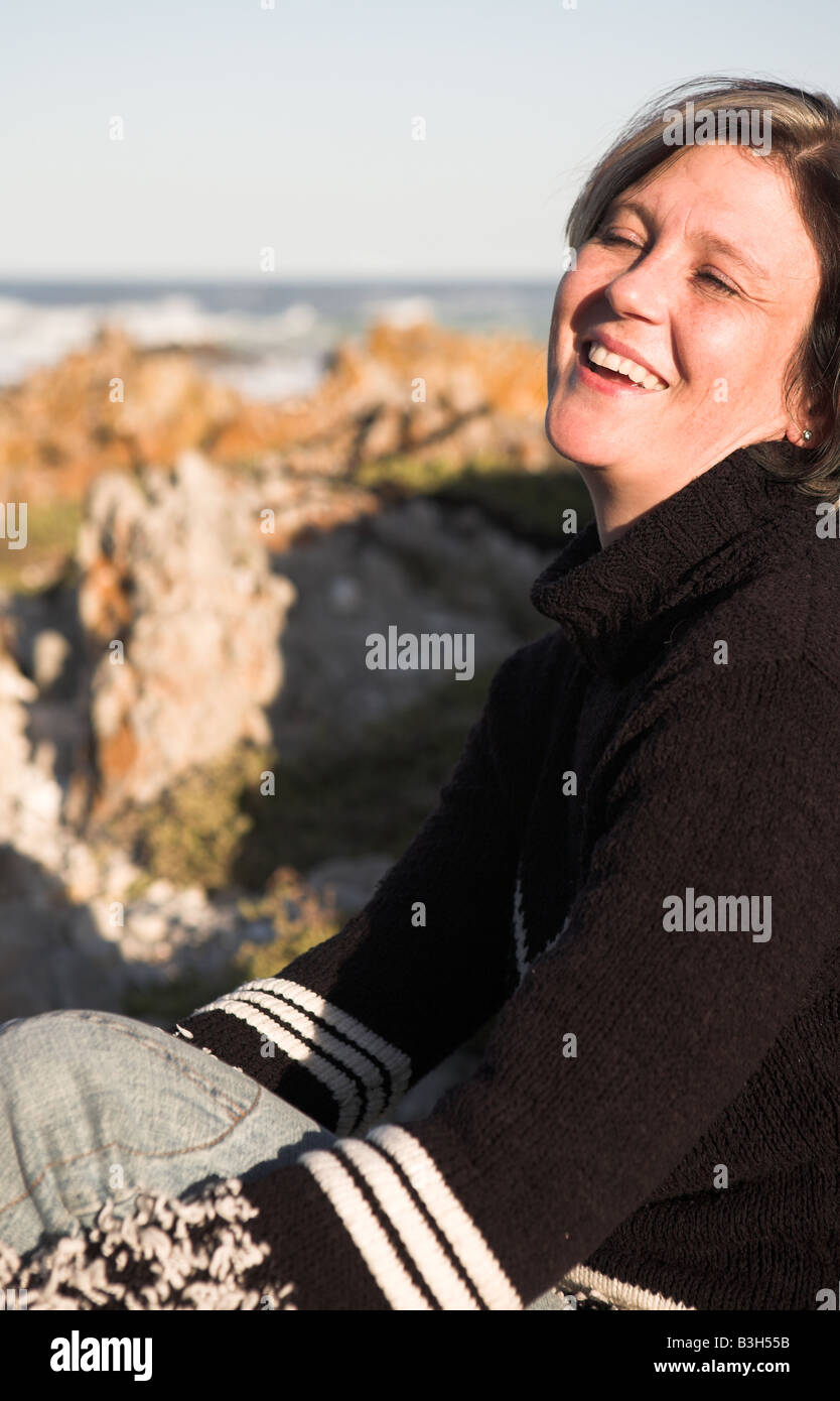 Beautiful Adult Woman With Short Hair Sitting On The Beach In The