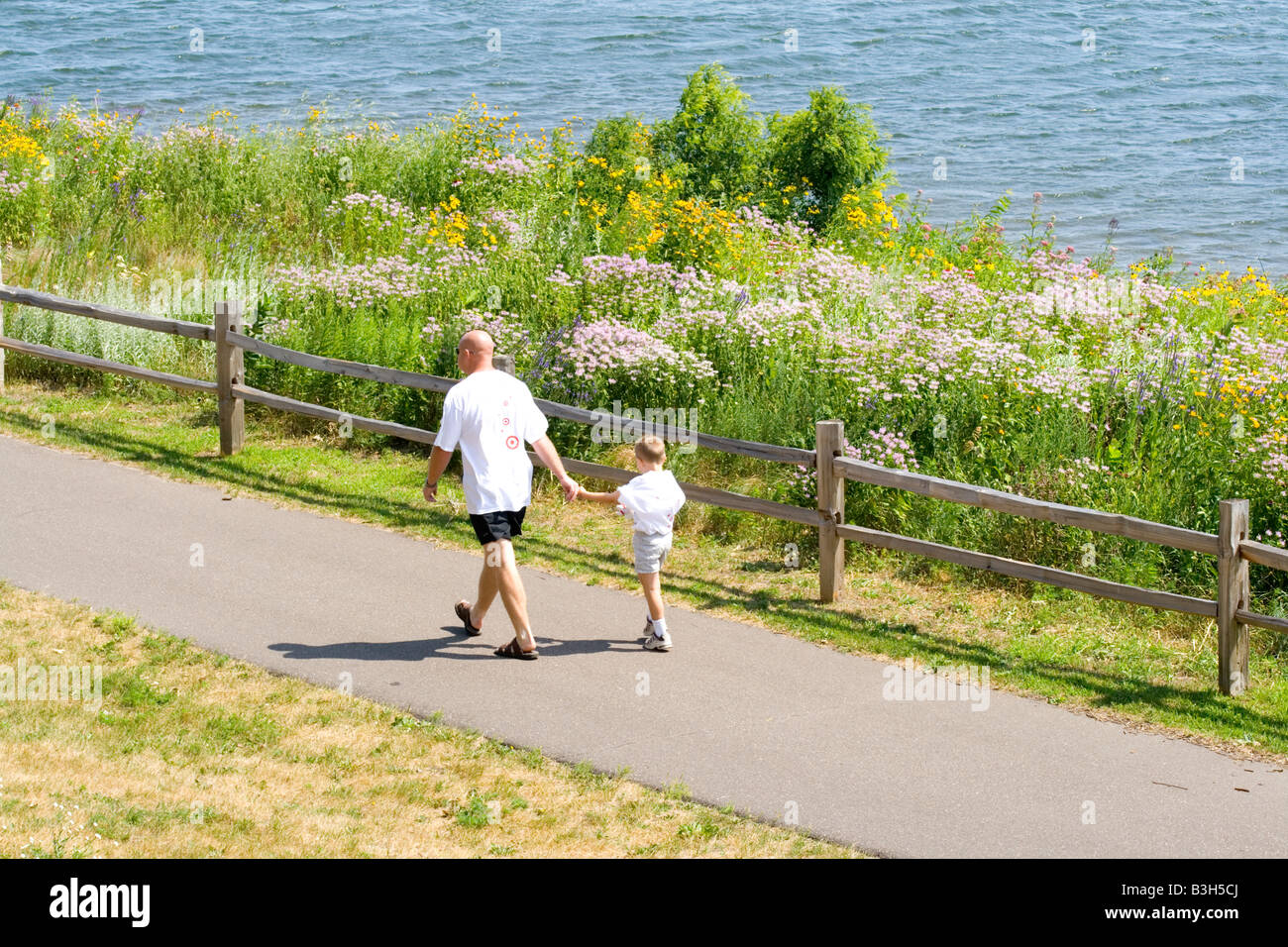 Dad and son walking along Lake Phalen Park shoreline path. St Paul